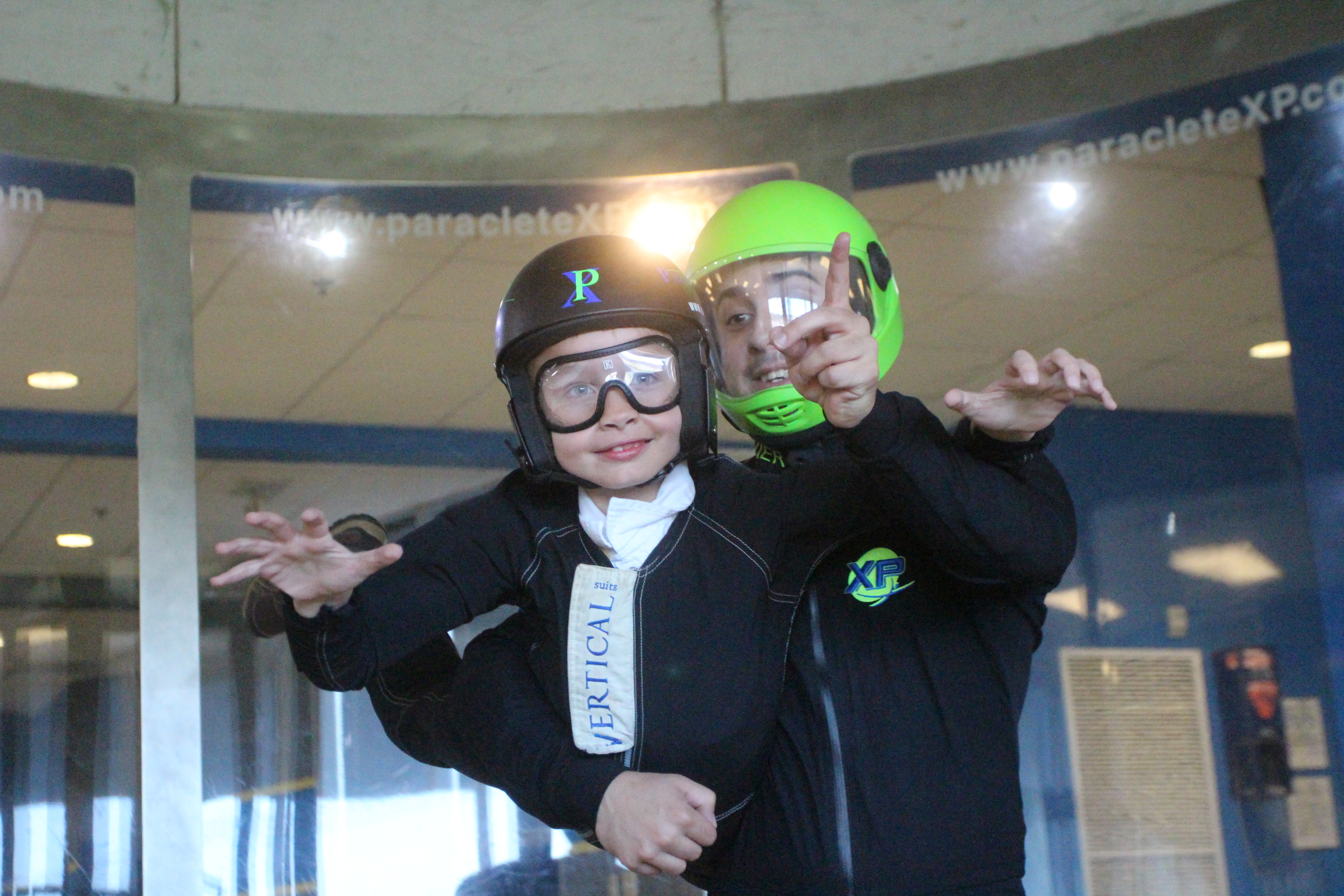 Young child loving the birthday party idea of indoor skydiving.