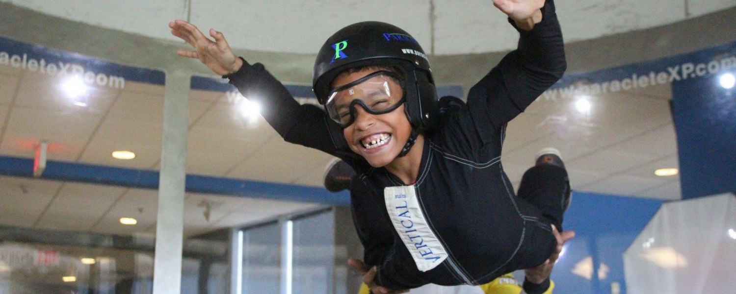 young kid flies in indoor skydiving wind tunnel