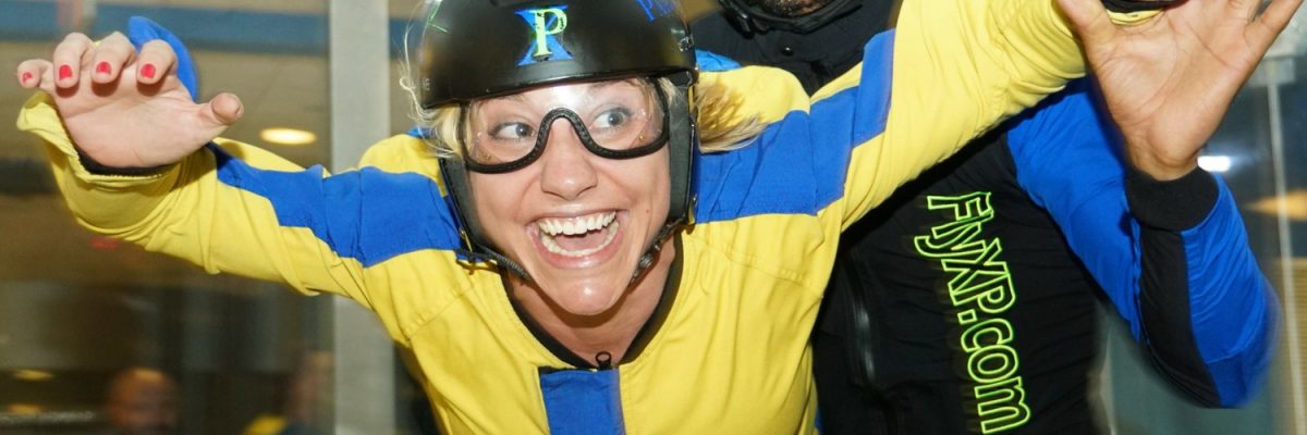woman excitedly indoor skydiving first time