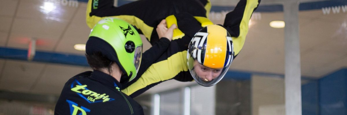 indoor skydiver receives coaching in the tunnel