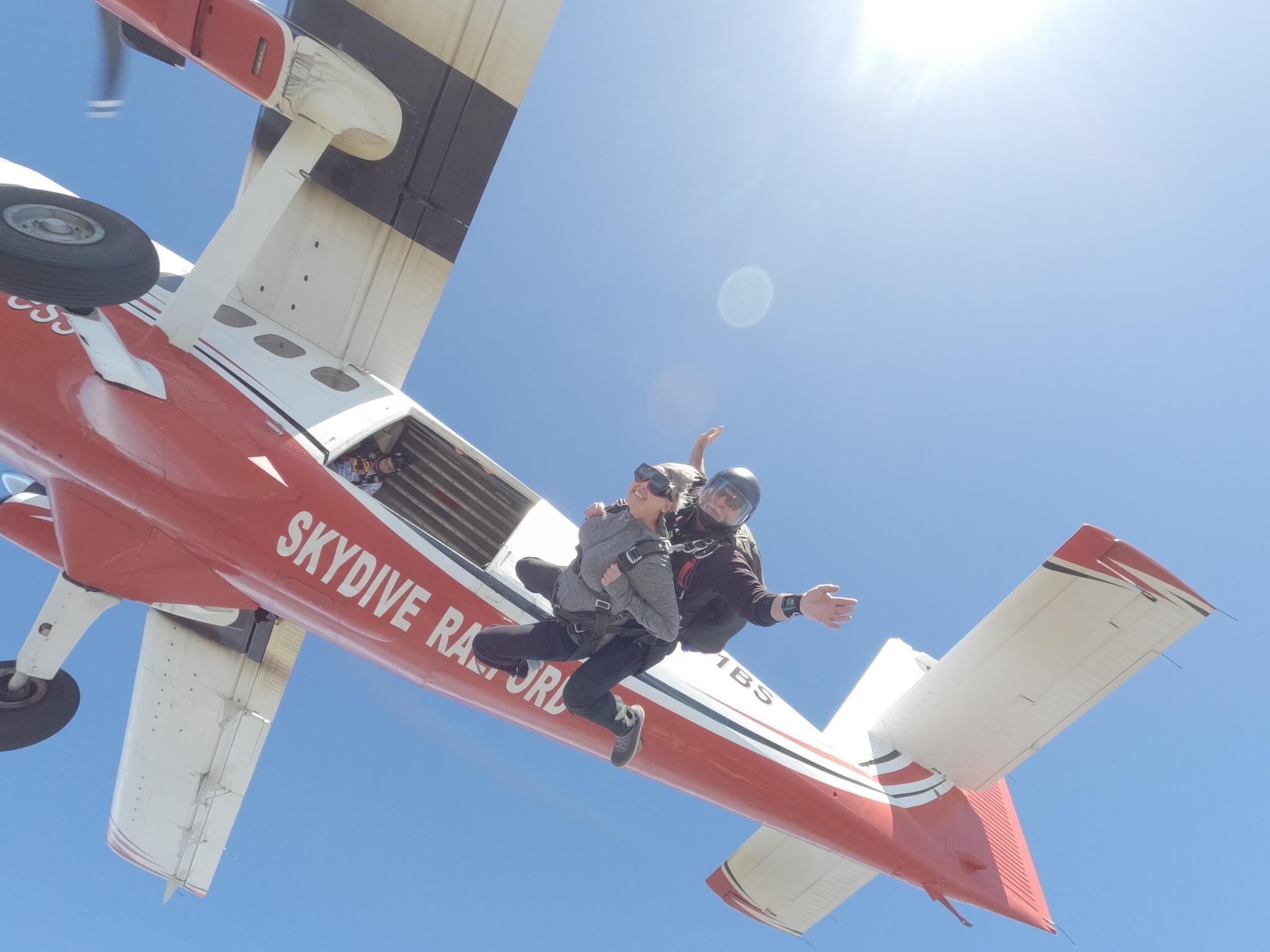 A tandem skydiving pair exiting the airplane