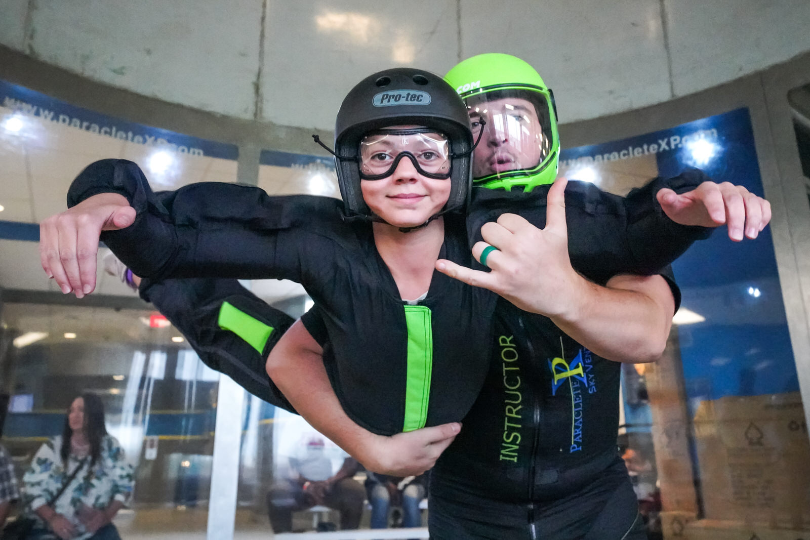 kid and indoor skydiving instructor smile in wind tunnel 