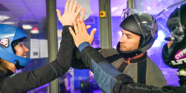 Indoor skydiving tunnel flyers high five