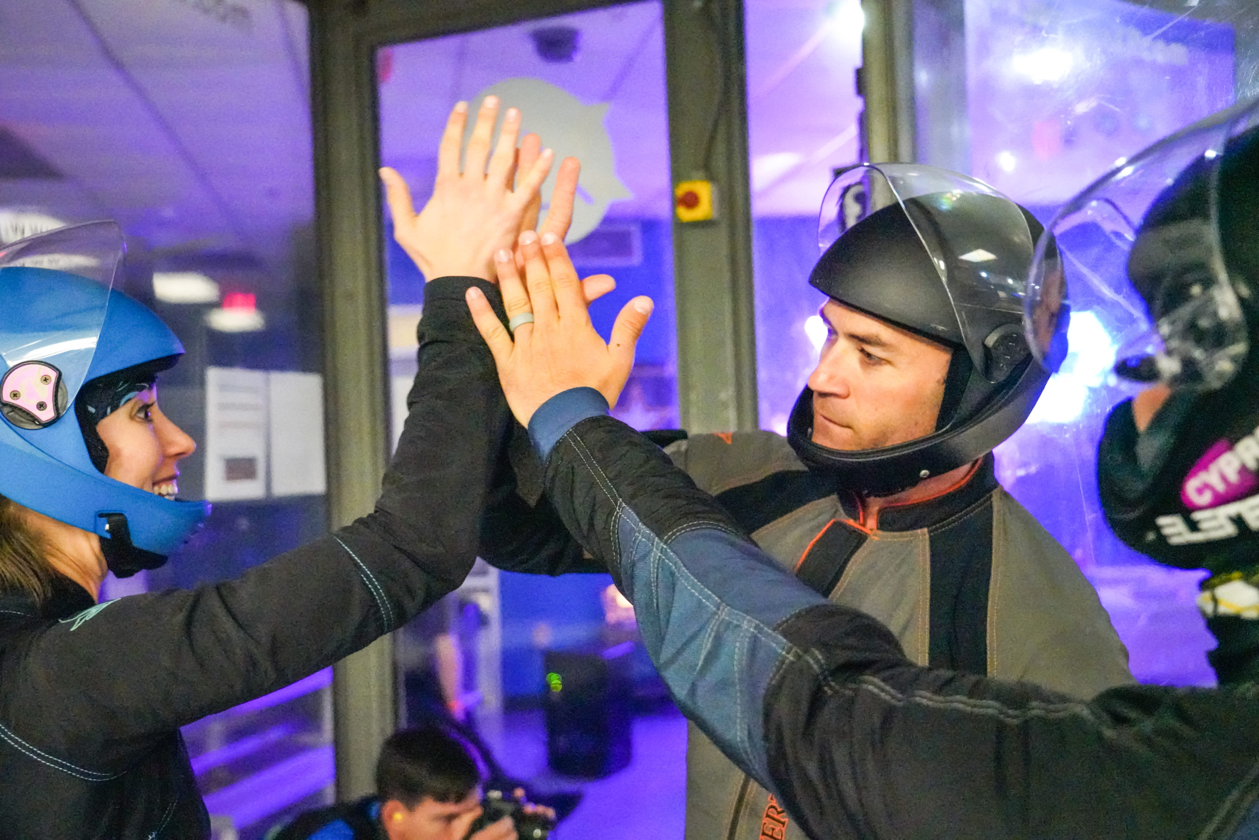 Indoor skydiving tunnel flyers high five 