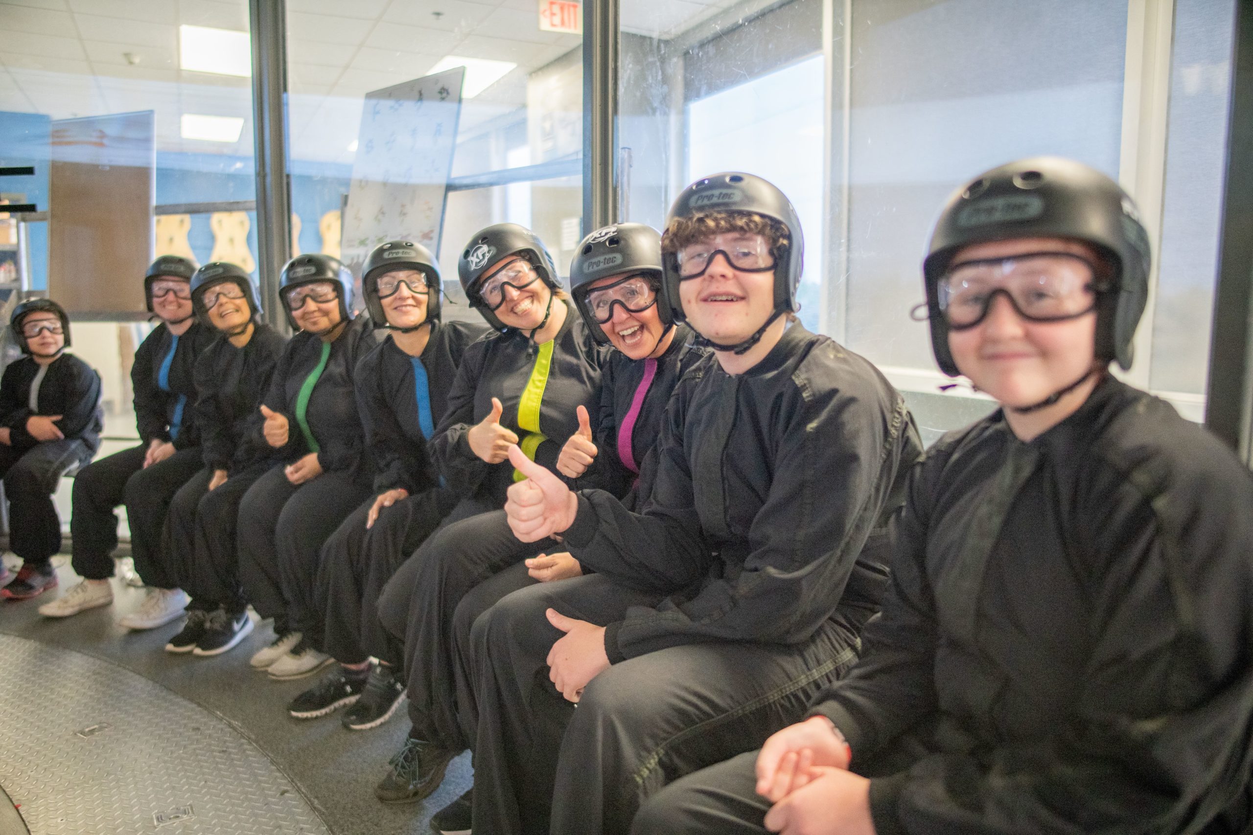 Indoor skydiving wind tunnel students sitting on bench 