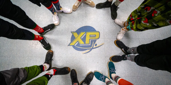 An above shot of feet pointing and touching toes around the Paraclete XP logo on the floor