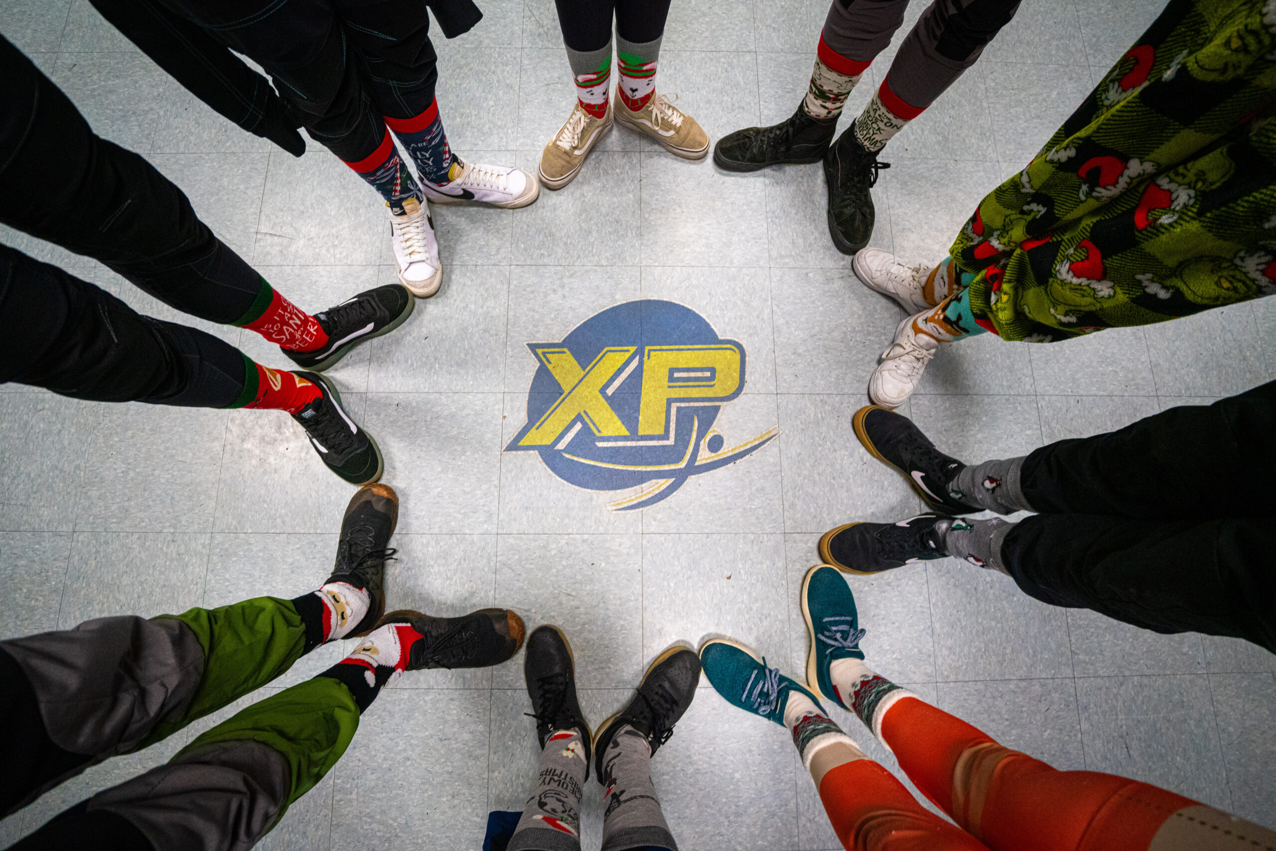 An above shot of feet pointing and touching toes around the Paraclete XP logo on the floor