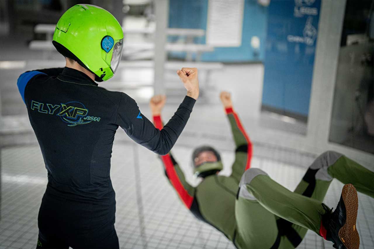 Indoor skydiving coach with a lime green helmet